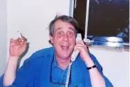 FL Decker in an office with a phone to his ear, a cigarette in his hand, and an excited expression